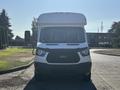 A 2017 Ford Transit-350 with a white exterior facing forward showcasing its front grille headlights and windshield