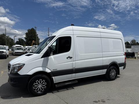 A white 2016 Mercedes-Benz Sprinter van with a high roof and black accents parked on a concrete surface