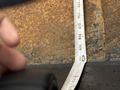 A measuring tape laid flat against a textured surface showing measurements in inches and centimeters
