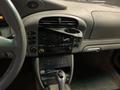 Interior of a 2003 Porsche 911 featuring a gear shifter audio controls and an empty cup holder