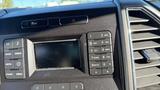 Interior dashboard controls of a 2016 Ford F-150 with radio buttons and a screen display