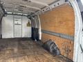 Interior of a 2022 GMC Savana cargo van featuring wooden paneling on the sides and a rubber mat on the floor