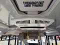 Interior view of a 2017 Chevrolet Express showing the ceiling with an emergency exit sign and air vents