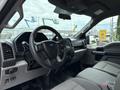 Interior dashboard and steering wheel of a 2018 Ford F-150 showcasing a modern design with gray seats and various controls