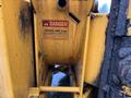 A yellow and black wood chipper with a warning sign that reads "DANGER" affixed to the body indicating safety precautions regarding the chipper disc