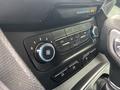 The dashboard controls of a 2019 Ford Transit Connect featuring climate control knobs and buttons for air conditioning and settings