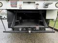 The image shows the rear view of a 2015 Freightliner M2 with a flatbed design featuring a textured surface and chains securing the edges
