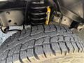 Close-up of a 2013 Ford Econoline's tire and suspension system showing a textured tire tread and coil spring on the vehicle's undercarriage