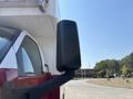 A side view mirror of a 2007 GMC C4500 TopKick with a black cylindrical design mounted on a red and white truck body