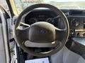 Steering wheel of a 2016 Ford Econoline with the Ford emblem visible in the center and dashboard controls in the background
