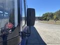 A side view mirror of a 2018 Grande West Vicinity bus showing a reflective surface and a sticker on the side of the vehicle