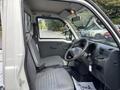 Interior view of a 2010 Daihatsu Hijet showing the driver's seat steering wheel and dashboard with light gray fabric upholstery
