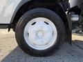 Close-up of a white wheel with a five-bolt pattern and a tire on a 2017 Isuzu NPR HD