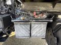 A dual battery setup featuring two black batteries with visible corrosion and connected wiring in a vehicle's engine compartment