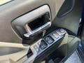Close-up of the driver's side door panel of a 2017 Chevrolet Silverado 1500 featuring a chrome door handle and control buttons for windows and locks