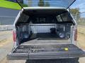 A 2014 Ford F-150 with an open truck bed displaying a lined cargo space and a retractable tailgate