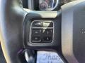 Close-up of the steering wheel controls of a 2014 RAM 5500 featuring buttons for voice recognition and navigation arrows