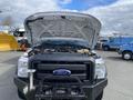 A 2015 Ford F-550 with its hood raised showcasing the engine compartment and the front grill displaying the Ford logo