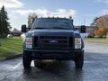 A front view of a black 2008 Ford F-550 with a large grille and several amber lights on the roof