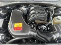 Engine compartment of a 2015 Dodge Charger featuring a large air intake and various components including hoses and a battery
