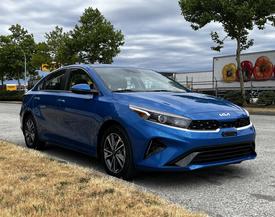 A blue 2023 Kia Forte parked with a sleek design featuring a distinctive front grille and modern headlights