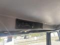 The interior of a 1997 Freightliner FL70 featuring a mounted Panasonic stereo system and a mesh speaker grille above the dashboard