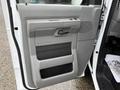 A close-up of the interior door panel of a 2013 Ford E-350 featuring gray plastic with a textured grip and a handle designed for easy opening