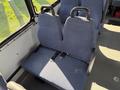 A row of blue upholstered seats with safety belts in a vehicle interior designed for passenger transport