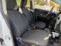 Two front seats of a 2012 Mitsubishi I-MiEV with a minimalist interior design and fabric upholstery