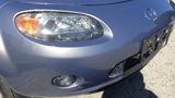 A silver 2007 Mazda Miata with a distinctive front end featuring round headlights and a small grille
