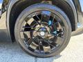 A close-up of a black alloy wheel with a multi-spoke design mounted on a Bridgestone tire from a 2023 Fisker Ocean