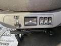 A control panel on the side of a truck seat featuring switches for adjusting seat height and backrest position