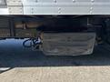 A 2022 Isuzu NQR truck featuring a metal fuel tank located underneath the chassis