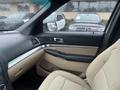 Interior view of a 2016 Ford Explorer with beige seating and dashboard features under rainy conditions