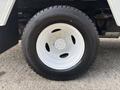 Close-up of a white wheel with a five-bolt pattern and a black tire clearly showing tread detail on a 2008 Ford Econoline