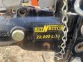 A close-up of a metal hitch with a yellow and black label that reads Hit N Hitch and displays a weight capacity of 22,000 lbs