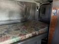 Interior of a 2009 Peterbilt Highway featuring a flat sleeping area with a patterned mattress and walls in a truck cab