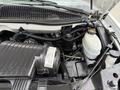 Engine compartment of a 2004 Chevrolet Express featuring an air intake system coolant reservoir and various hoses and components