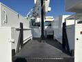 2005 Freightliner M2 106 bucket truck with an open cargo area featuring black diamond plate flooring and white side panels