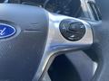 Close-up of a 2016 Ford Escape steering wheel with multimedia control buttons on the left side