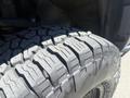 Close-up of a tire from a 2010 Toyota Tacoma showcasing deep tread patterns designed for off-road traction