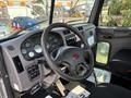 Interior view of a 2020 Peterbilt 330 featuring a steering wheel dashboard with multiple gauges and controls near the driver's seat