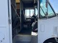A 2012 Ford Econoline with an open driver's side door showcasing the interior featuring a steering wheel and driver's seat