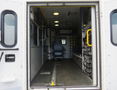 Interior view of a 2011 Chevrolet Express showing an empty cargo space with a single driver's seat at the back and floor-mounted rails for securing cargo