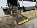 A wheelchair lift with a yellow and black platform extending from a 2020 Chevrolet Express vehicle