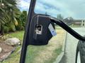 Close-up of a door handle on a 2009 New Holland T4020 tractor showing the metal latch and keyhole