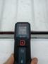 A hand holding a Bosch Blaze laser distance measurer displaying a measurement of 8.460 ft