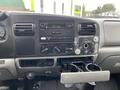 Dashboard of a 2005 Ford F-350 SD featuring a stereo system climate control knobs and a cup holder