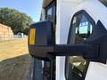 Close-up of the side mirror of a 2017 Chevrolet Express featuring a yellow reflective strip