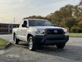 A silver 2013 Toyota Tacoma pickup truck with a black front grille and chrome accents parked at an angle on a gravel surface